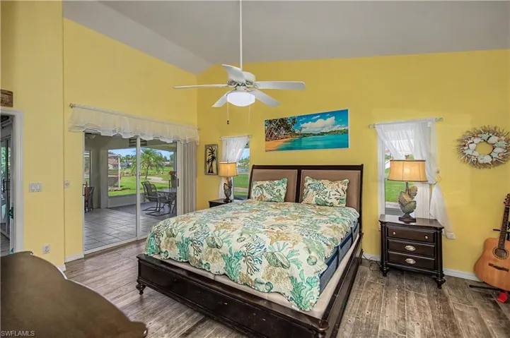 Bedroom featuring vaulted ceilings, wood-finish flooring, and a ceiling fan with integrated lighting