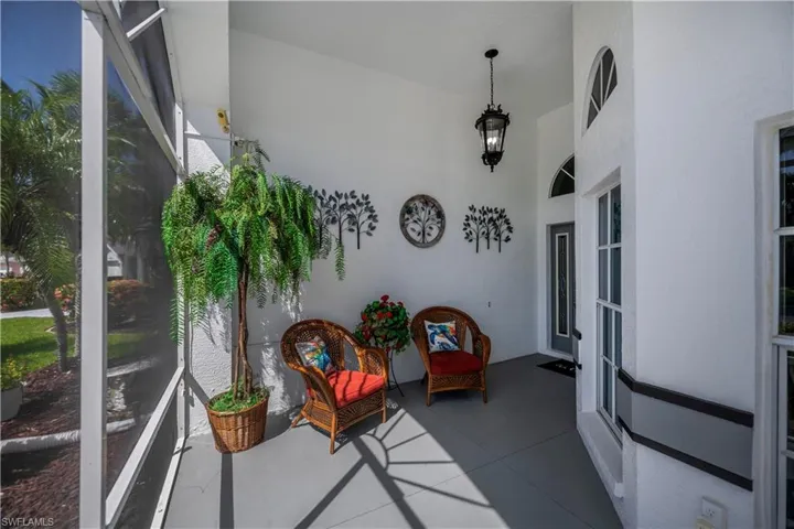 Screened entry porch featuring an arched transom window and a dark-paneled entry door