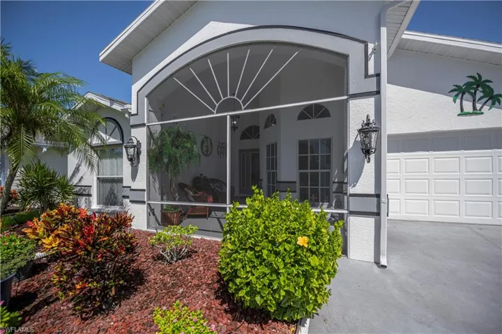 Screened entryway featuring an arched transom and decorative exterior lighting