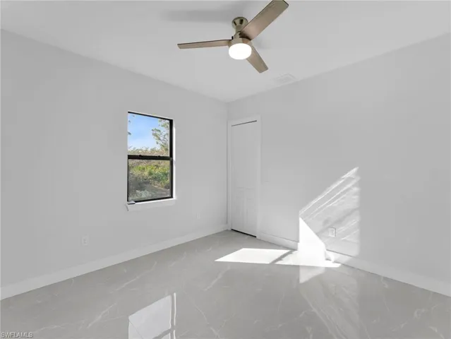 Empty room with a ceiling fan and baseboards