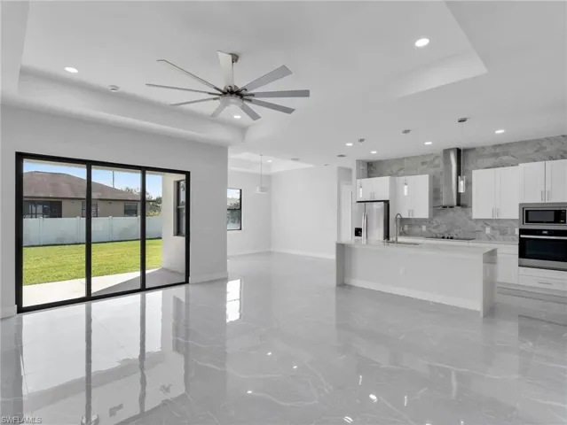 Kitchen with white cabinets, a tray ceiling, stainless steel appliances, and light countertops