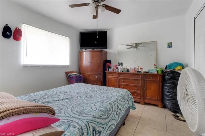Bedroom with light tile patterned flooring and a ceiling fan