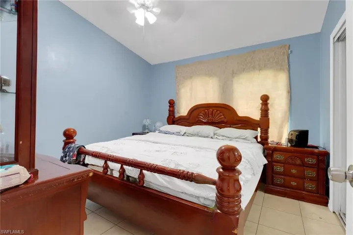 Bedroom featuring light tile patterned floors, ceiling fan, and vaulted ceiling