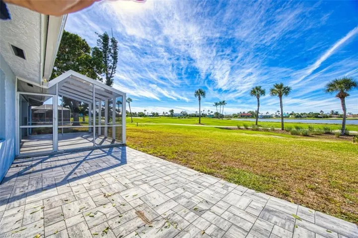 View of patio featuring water and golf course views