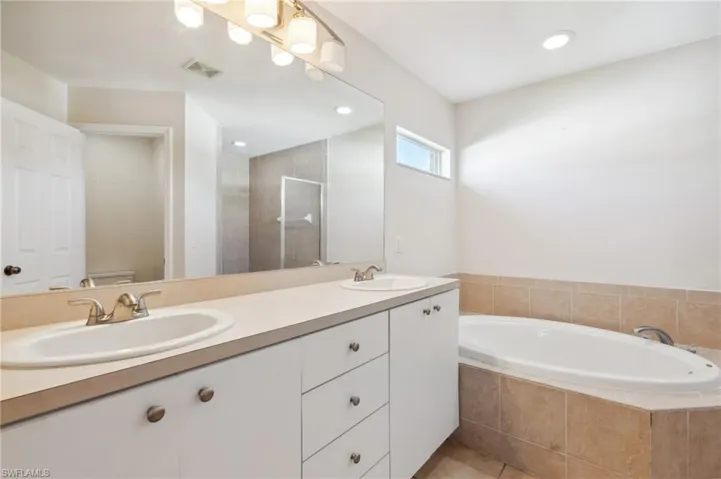Full bathroom with vanity, toilet, independent shower and bath, and tile patterned flooring
