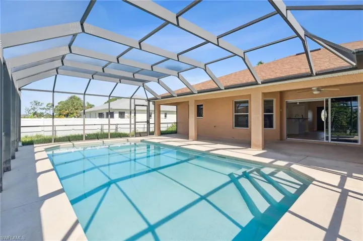 View of pool with a lanai, ceiling fan, and a patio area
