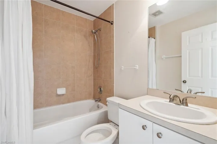 Full bathroom with shower / bath combo, toilet, and vanity