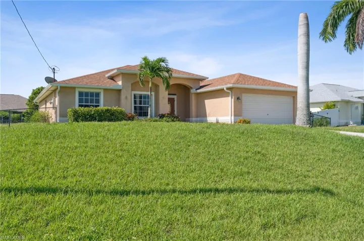 View of front of house with a garage and a front lawn