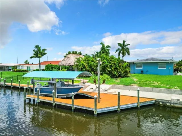 Dock area featuring a lawn, boat lift, and a water view