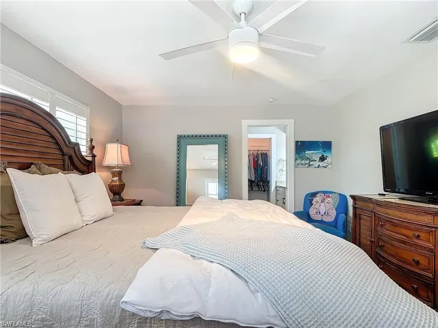 Bedroom with ceiling fan and a spacious closet