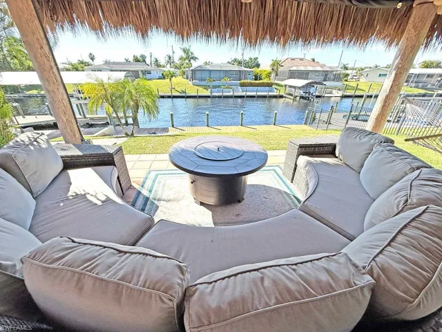 View of patio / terrace featuring an outdoor living space, a dock, a water view, and boat lift