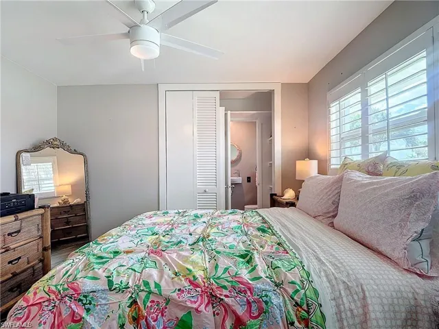 Bedroom featuring multiple windows, ceiling fan, and a closet