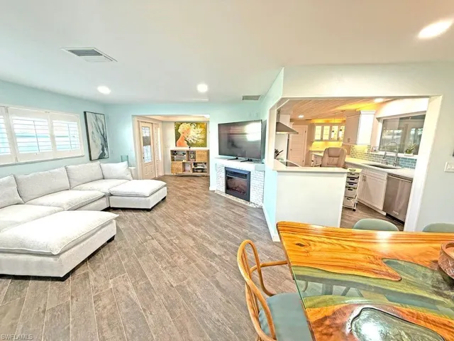 Living area featuring plenty of natural light, a fireplace, light wood finished floors, and recessed lighting