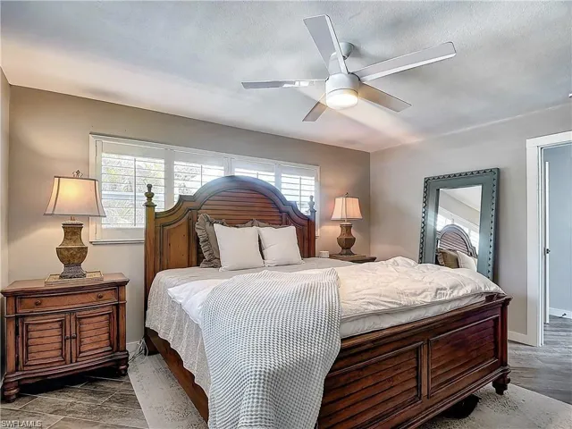 Bedroom with multiple windows, ceiling fan, and wood finished floors