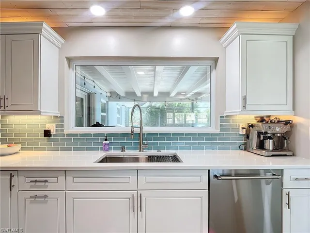 Kitchen featuring white cabinetry, oven, a warming drawer, ventilation hood, and decorative backsplash
