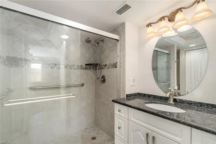 Master Bathroom with tiled shower and solid stone countertops.