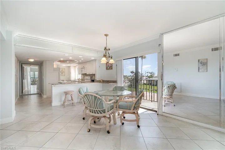 Dining area featuring light tile patterned floors, ornamental molding, and baseboards