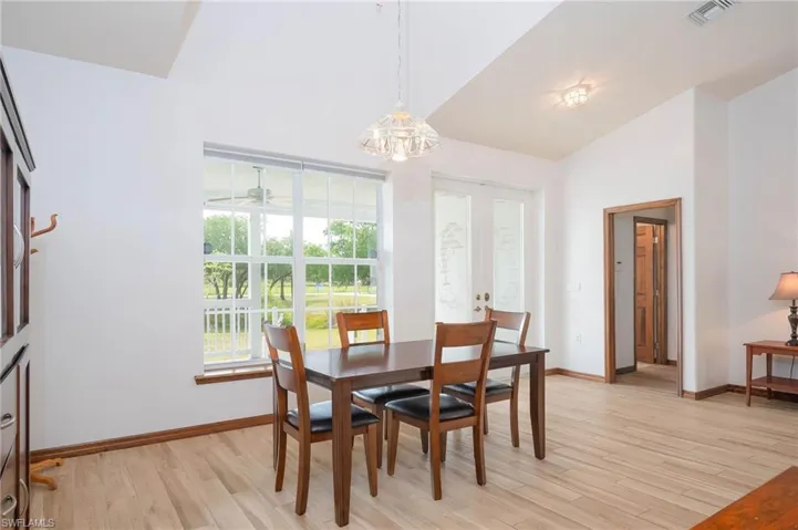 Dining space with a chandelier, wood baseboards, and high vaulted ceiling