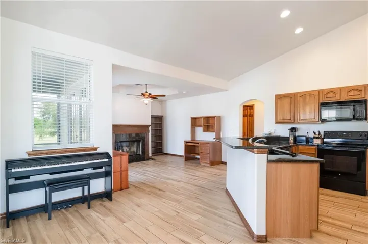 Breakfast nook Kitchen with black appliances, a ceiling fan, a high end fireplace, and recessed lighting