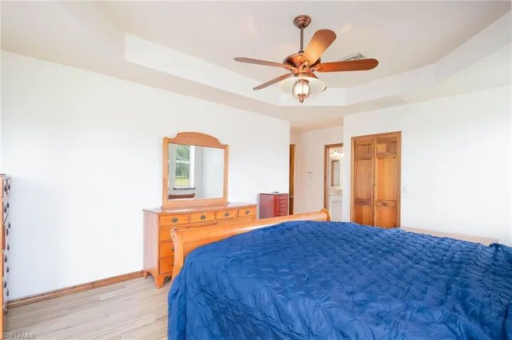 Bedroom featuring a tray ceilingand a ceiling fan