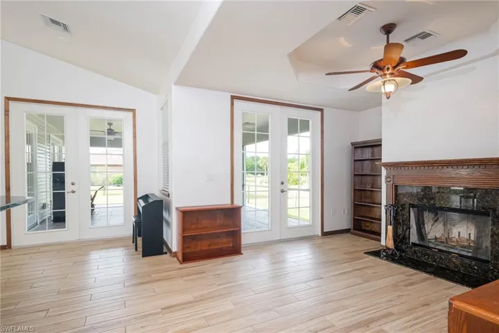 Living room featuring french doors, ceiling fan,  and a working  fireplace