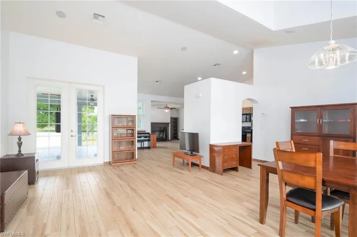 Living Room and Dining room with arched walkways, a ceiling fan, high vaulted ceiling, and a chandelier