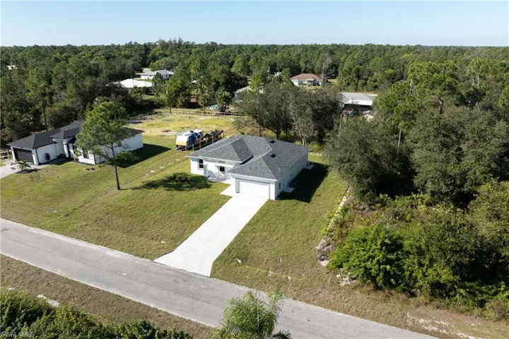 Aerial view of property and surrounding area featuring a forest