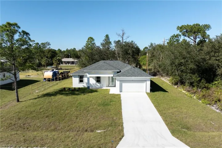 View of front of property with driveway, an attached garage, and stucco siding