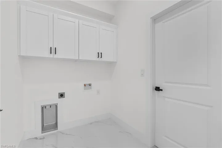 Laundry room with washer hookup, cabinet space, light marble finish flooring, and hookup for an electric dryer