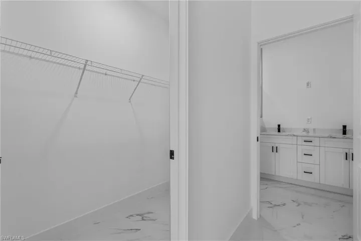 Laundry area with baseboards and light marble finish flooring