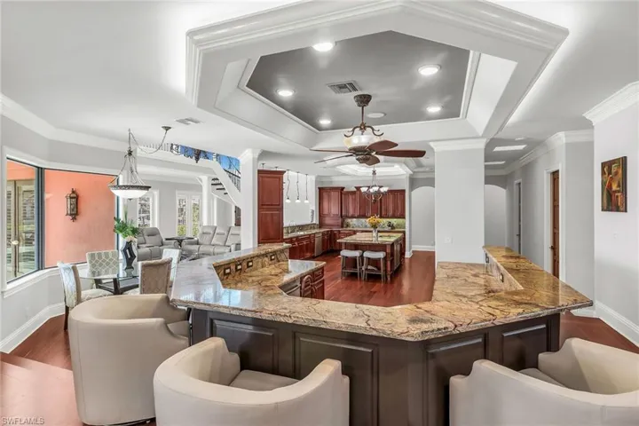 Central wet bar with dishwasher, sink and wine cooler. granite countertop.