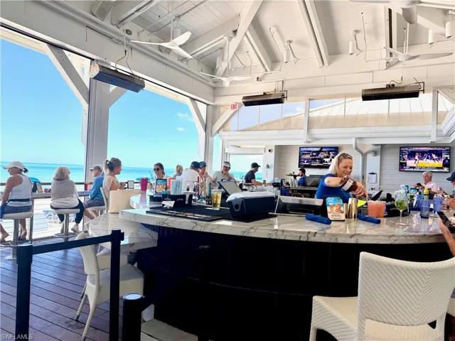 Open-air bar area featuring a white marble-look countertop and textured dark wood-finish bar