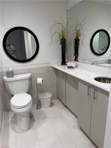 Bathroom featuring a full vanity with light grey cabinetry and brushed nickel hardware, a white countertop, and an integrated circular sink