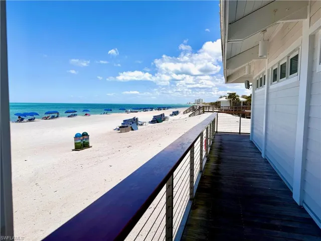 Expansive waterfront deck featuring wood-finish flooring and a cable railing system