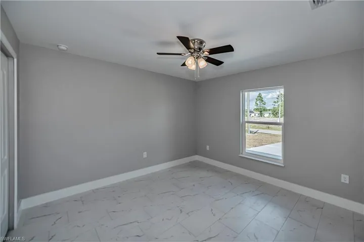 Empty room featuring ceiling fan and light tile floors