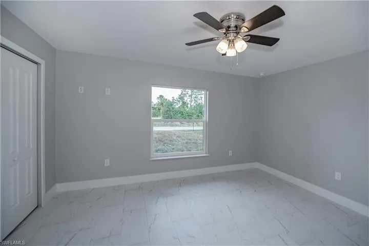 Tiled empty room featuring ceiling fan