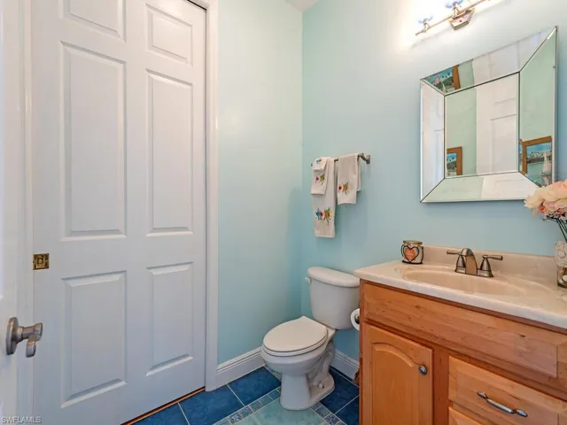 Half bathroom with tile patterned floors and vanity