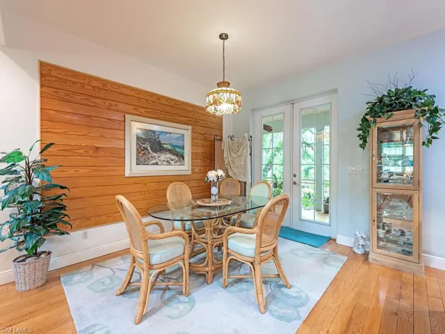 Dining room with french doors, wood-type flooring, and a chandelier