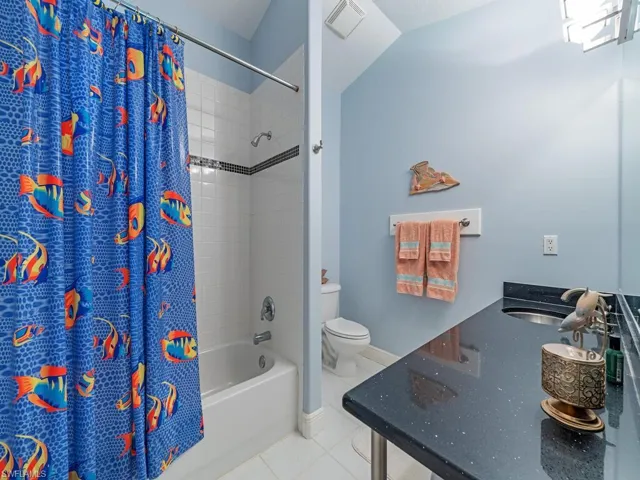 Bathroom featuring tile patterned floors and shower / bath combo with shower curtain