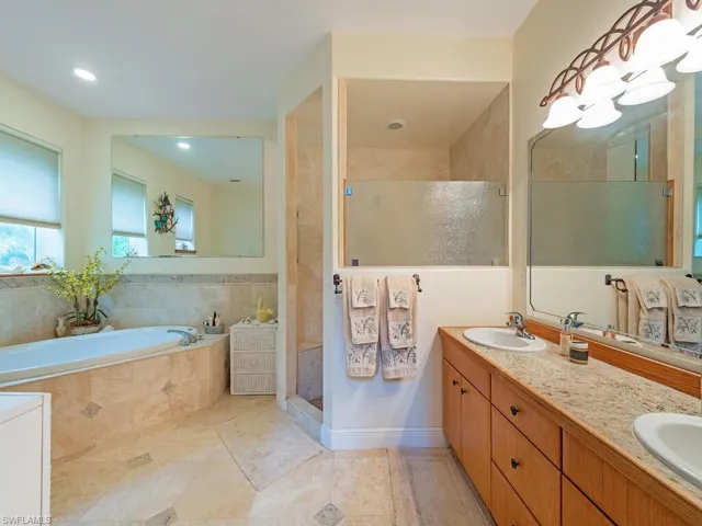 Full bathroom with a garden tub, double vanity, and a stall shower