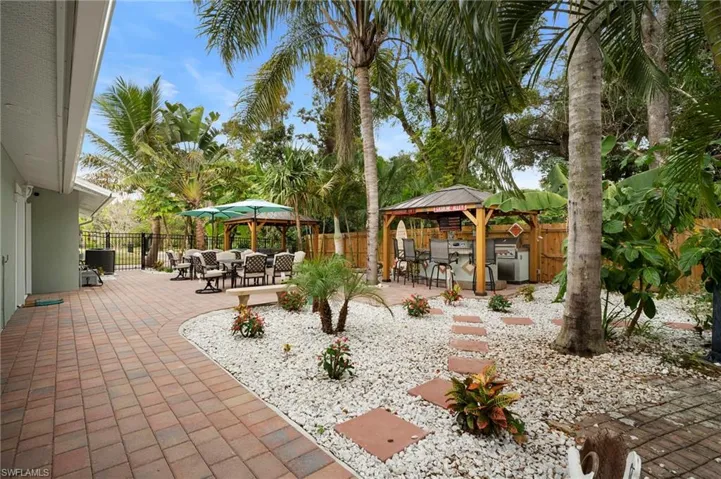 Fenced backyard with a gazebo, a patio area, and outdoor dining space