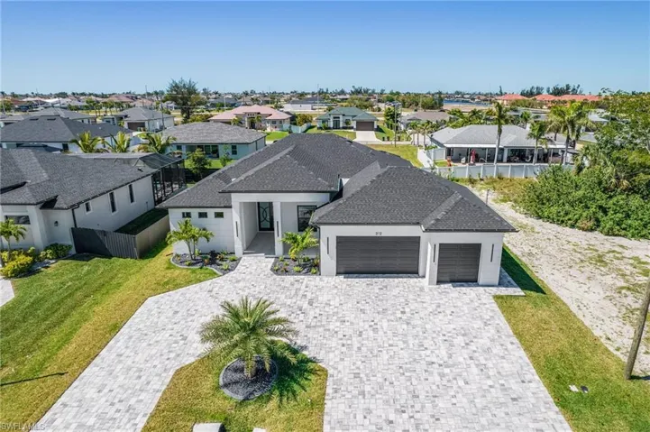 View of front of property with stucco siding, a front lawn, decorative driveway, a residential view, and a garage