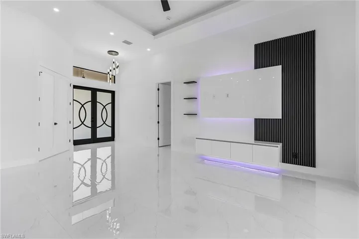 Empty room with visible vents, baseboards, a tray ceiling, recessed lighting, and marble finish floor