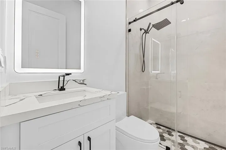 Full bathroom featuring vanity, a shower stall, and toilet
