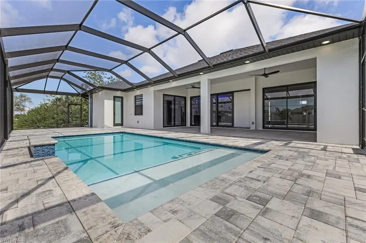 Pool featuring a lanai, ceiling fan, and a patio area
