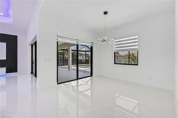 Spare room featuring baseboards, marble finish floor, and a wealth of natural light