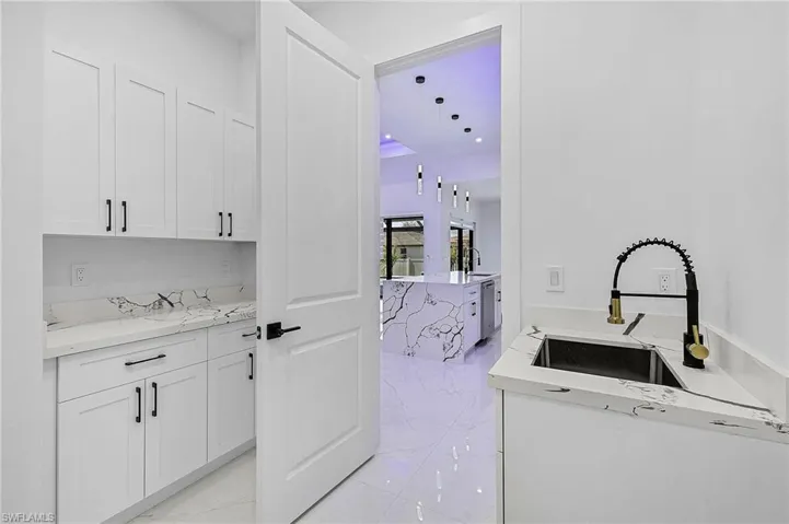 Laundry area with a sink and marble finish floor