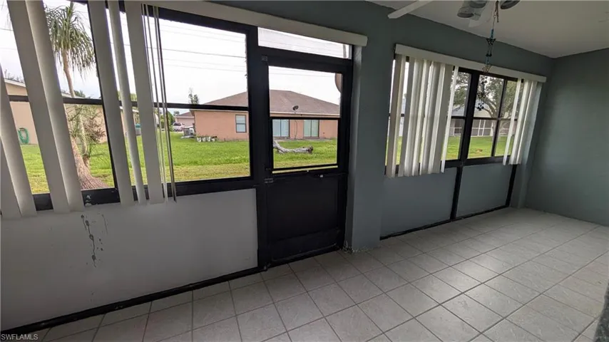 Unfurnished sunroom featuring ceiling fan