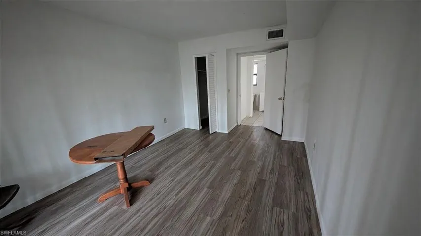 Unfurnished bedroom featuring dark wood-style floors and a closet