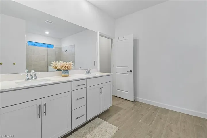 Bathroom featuring double sink vanity and wood-type flooring